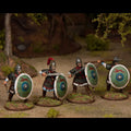 Four miniature figures of soldiers with shields and swords in a forest setting